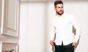 Mężczyzna w białej koszuli i jeansach, prezentujący styl slim fit.