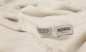 Miękka, kremowa paszmina z metkami: "100% Cashmere, Hand made in Nepal, Dry clean only" i "MINOU Cashmere".