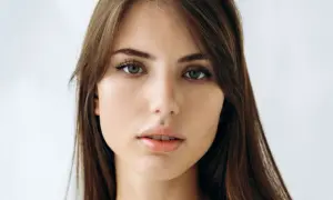 Delikatna, soft girl z zielonymi oczami i brązowymi włosami, patrzy prosto w obiektyw.