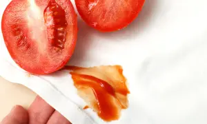 Niefortunny wypadek z pomidorem! Na białej tkaninie pojawiła się wyraźna plama z pomidora, która wymaga natychmiastowego czyszczenia.