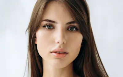 Delikatna, soft girl z zielonymi oczami i brązowymi włosami, patrzy prosto w obiektyw.
