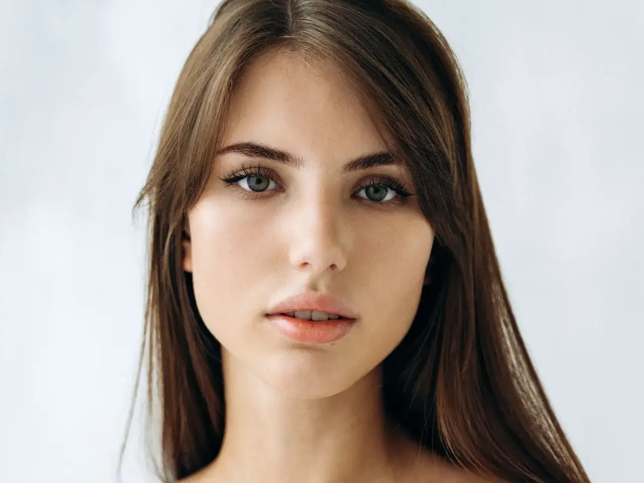 Delikatna, soft girl z zielonymi oczami i brązowymi włosami, patrzy prosto w obiektyw.