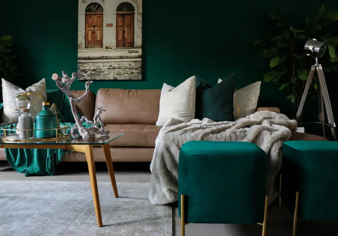 Elegancki salon z brązową kanapą, zielonymi akcentami i złotymi dodatkami. Jaki kolor pasuje do zielonego? Złoto i beż tworzą luksusową kompozycję.