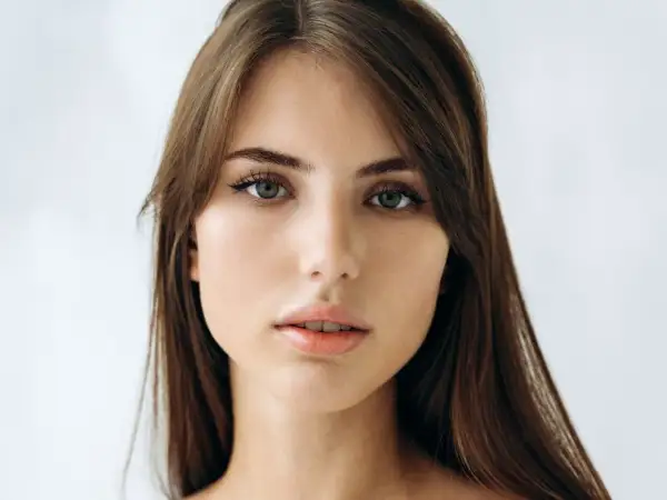 Delikatna, soft girl z zielonymi oczami i brązowymi włosami, patrzy prosto w obiektyw.